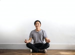 A person practicing mindfulness and meditation through yoga.